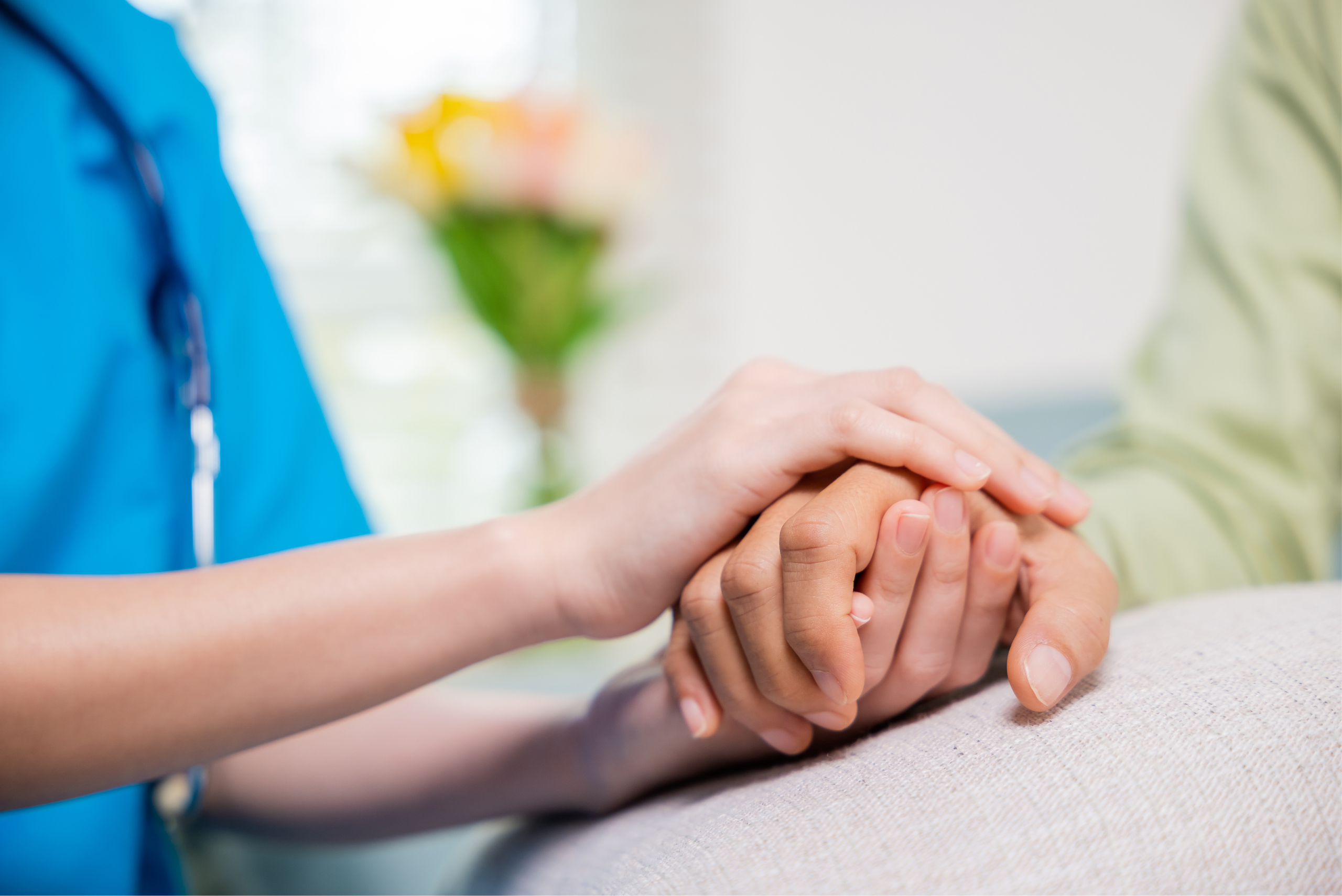 Nurse holding hand of a care resident.