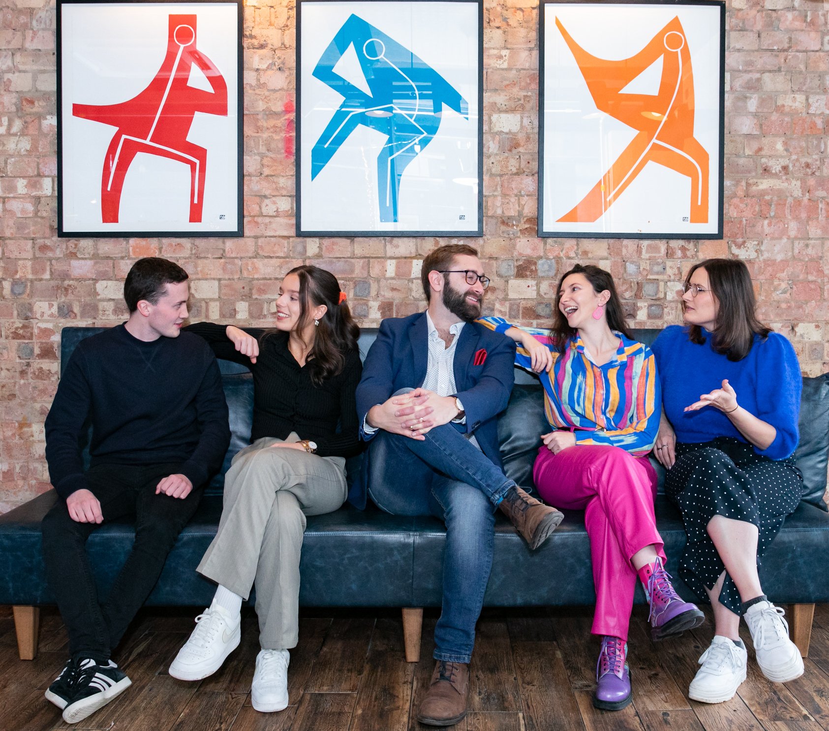 Wagada Digital Team on sofa smiling and chatting about marketing.