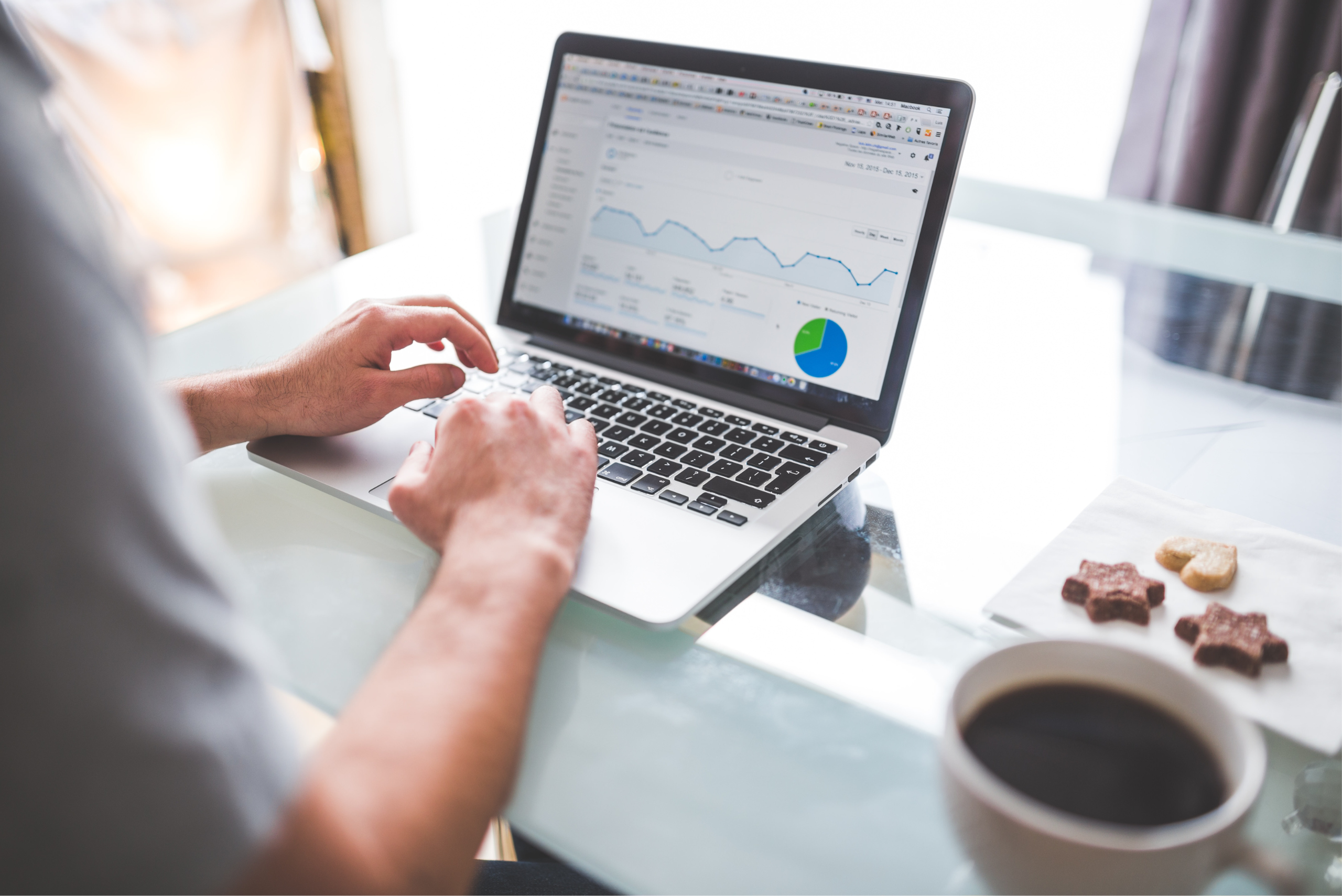 Person typing on laptop showing Google Analytics.