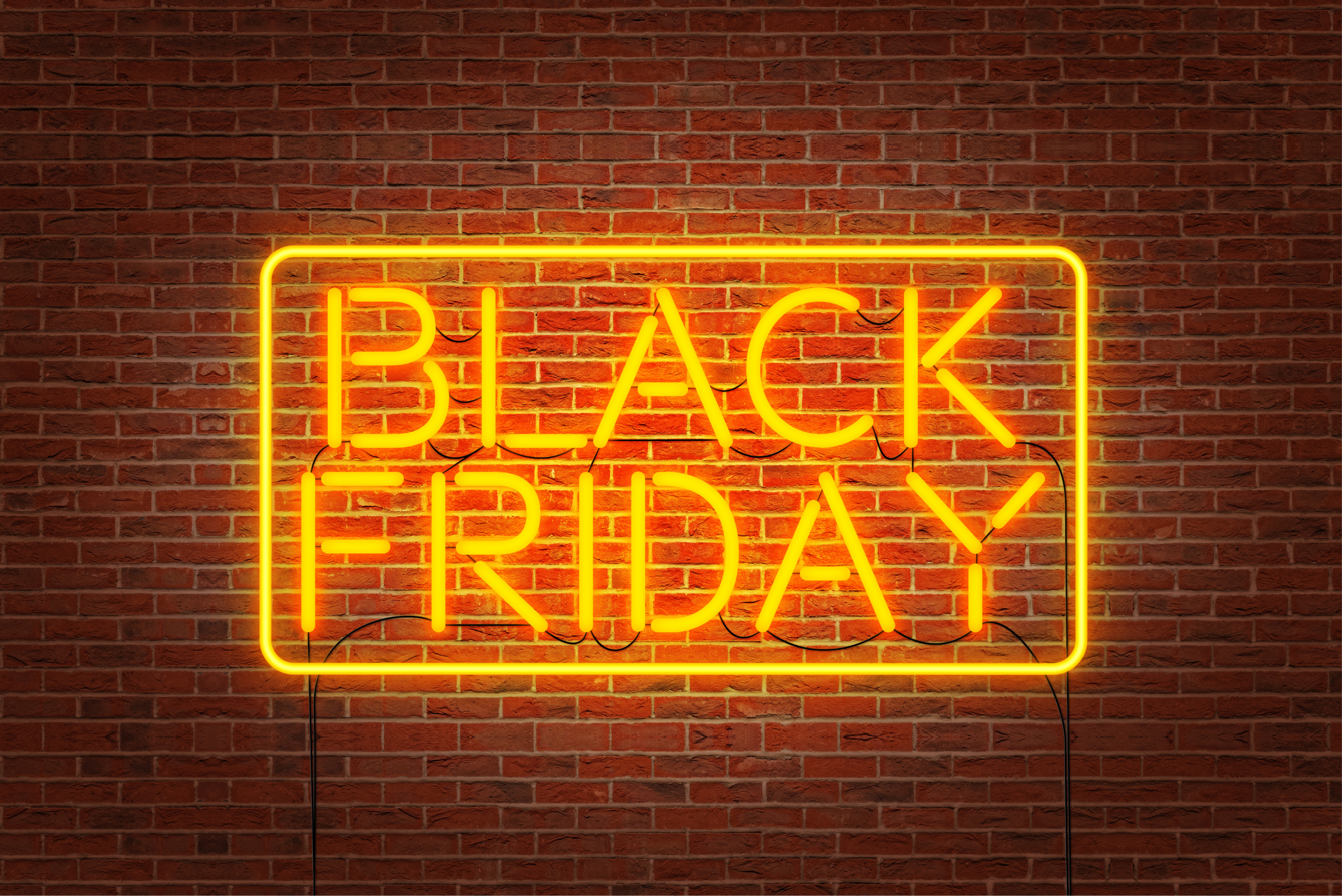 A yellow neon sign saying Black Friday against a brick wall.