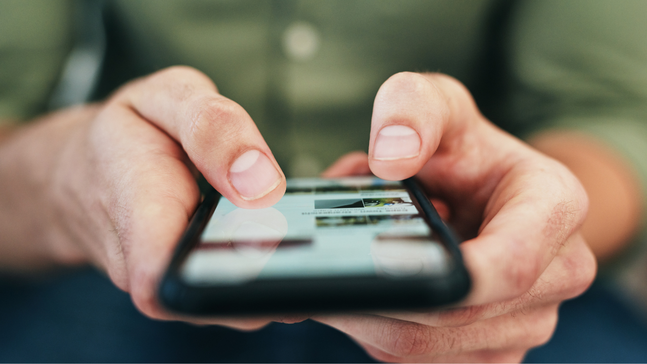 man on his phone reading a social media advert