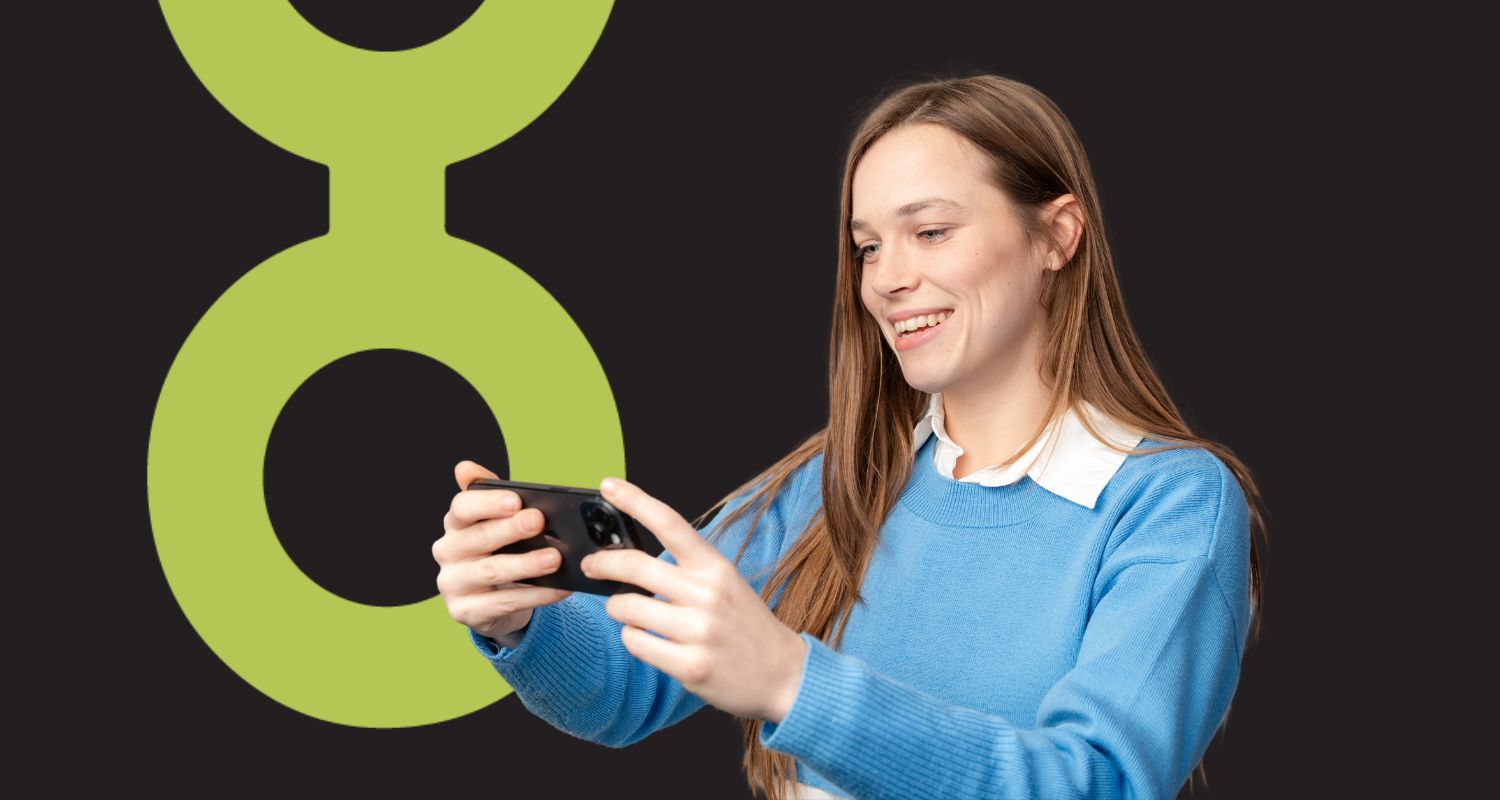 lady in a blue sweater looking at her phone in landscape orientation